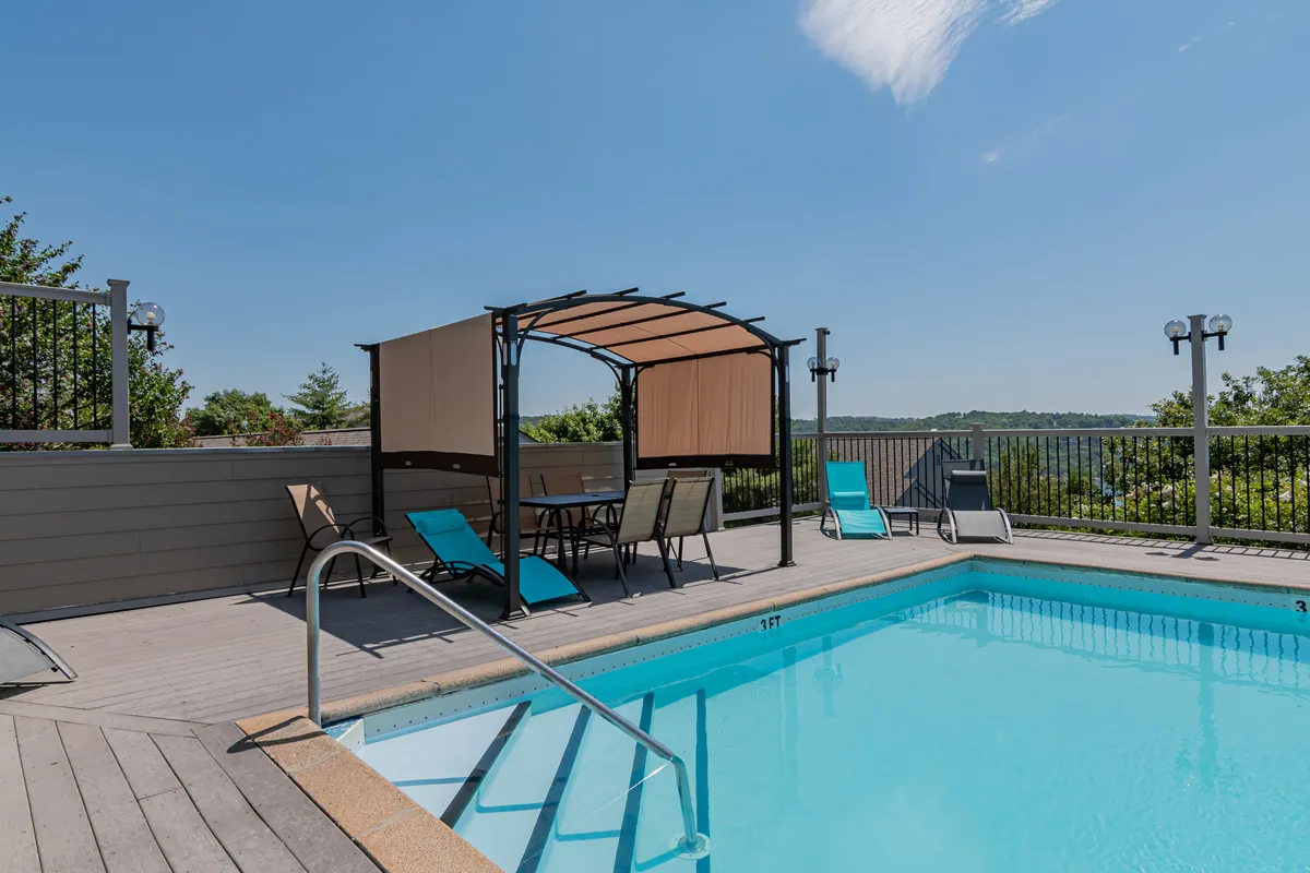 A tranquil pool area with canopy seating, lounge chairs, and expansive landscape views. The setting is ideal for both playful gatherings and relaxing moments, encouraging community interaction and enjoyment of the outdoors.